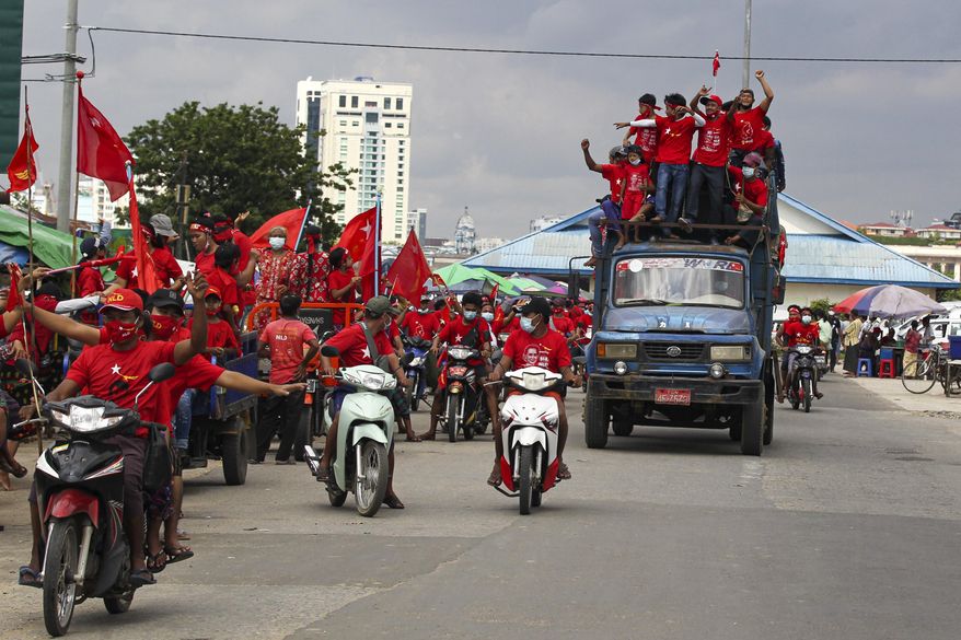 Supporters wearing shirts with logos of the Myanmar Leader Aung San Suu Kyi's National League for Democracy (NLD) cheer as they take part in the final day of campaigning for the Nov. 8 elections Friday, Nov. 6, 2020, in Data township, Yangon, Myanmar. Myanmar's citizens go to the polls Sunday in an effort to sustain the fledgling democracy they helped install just five years ago. (AP Photo/Thein Zaw)
