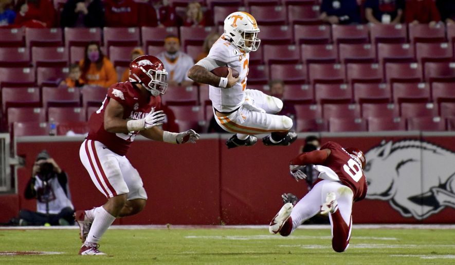 Tennessee quarterback Jarrett Guarantano (2) is tackled by Arkansas defenders Isaiah Nichols, left, and Greg Brooks Jr. during the second half of an NCAA college football game Saturday, Nov. 7, 2020, in Fayetteville, Ark. (AP Photo/Michael Woods)