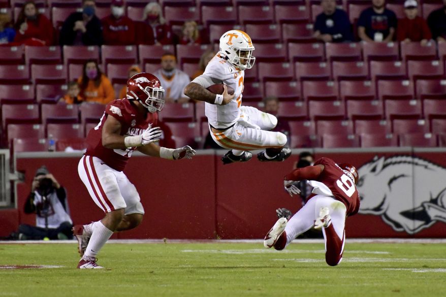 Tennessee quarterback Jarrett Guarantano (2) is tackled by Arkansas defenders Isaiah Nichols, left, and Greg Brooks Jr. during the second half of an NCAA college football game Saturday, Nov. 7, 2020, in Fayetteville, Ark. (AP Photo/Michael Woods)