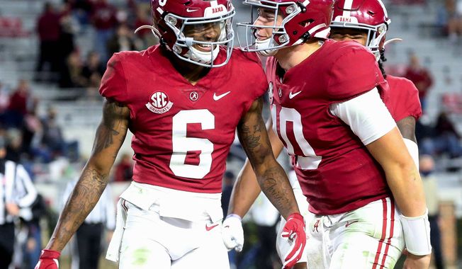 Receiver DeVonta Smith (left), quarterback Mac Jones and Alabama are ranked No. 1 in the Top 25 for the first time this season.  Alabama has been No. 1 for at least one week for 13 consecutive seasons. (The Tuscaloosa News via ASSOCIATED PRESS)