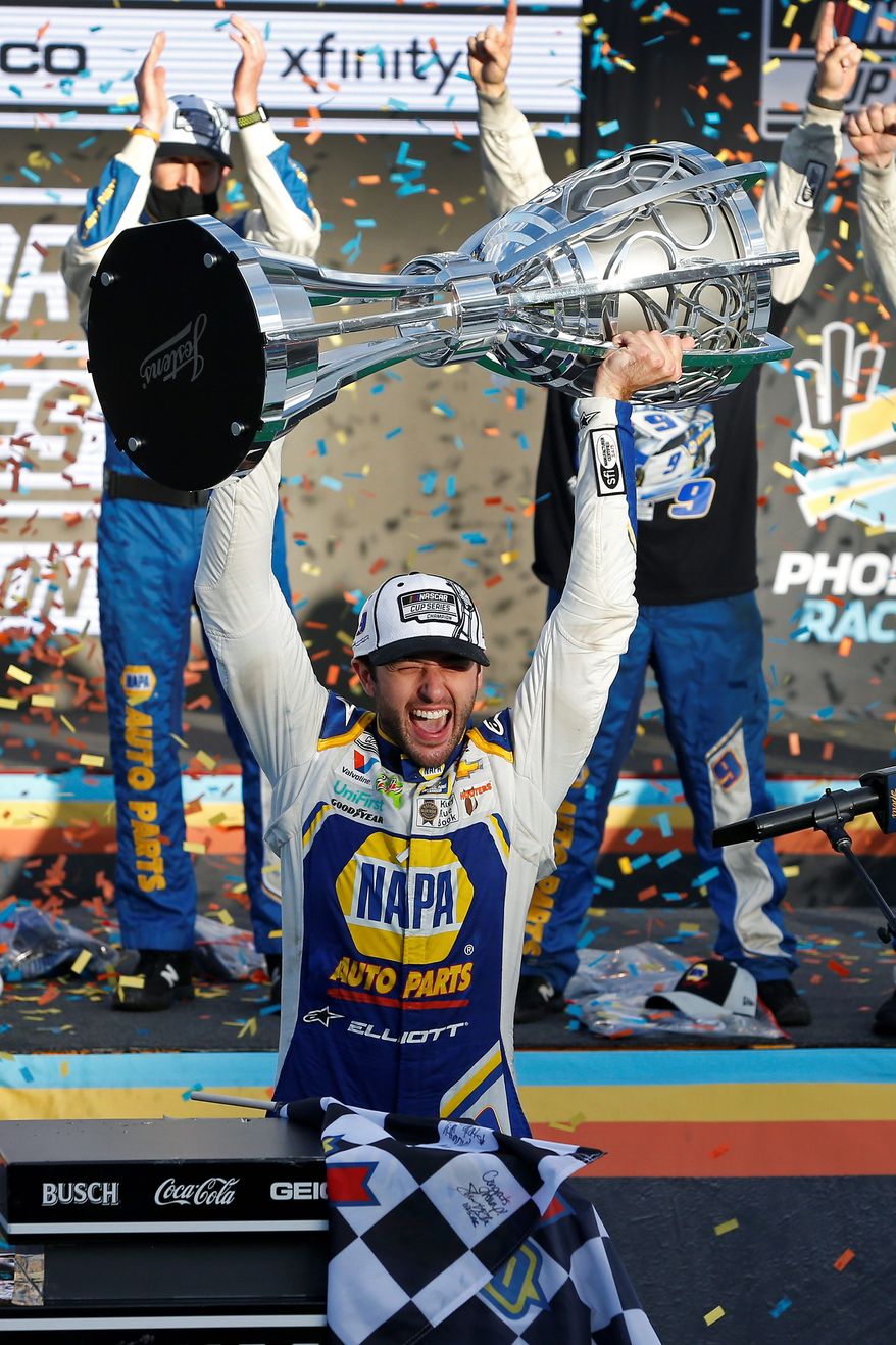 Chase Elliott holds up the NASCAR Cup Series trophy after winning Sunday in Phoenix. He is the third-youngest champion in NASCAR history. (ASSOCIATED PRESS)