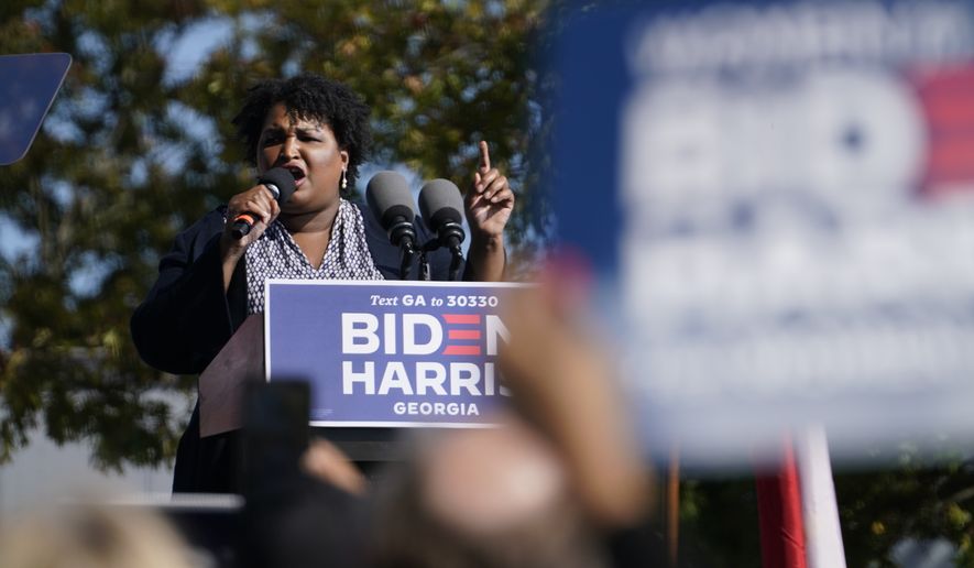 In this Nov. 2, 2020, photo, Stacey Abrams speaks to supporters as they wait for former President Barack Obama to arrive and speak at a rally as he campaigns for Democratic presidential candidate former Vice President Joe Biden, at Turner Field in Atlanta. (AP Photo/Brynn Anderson)