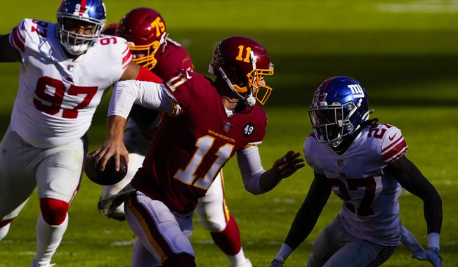 Washington Football Team quarterback Alex Smith (11) runs to avoid being tackled by New York Giants cornerback Isaac Yiadom (27) in the first half of an NFL football game, Sunday, Nov. 8, 2020, in Landover, Md. (AP Photo/Susan Walsh)