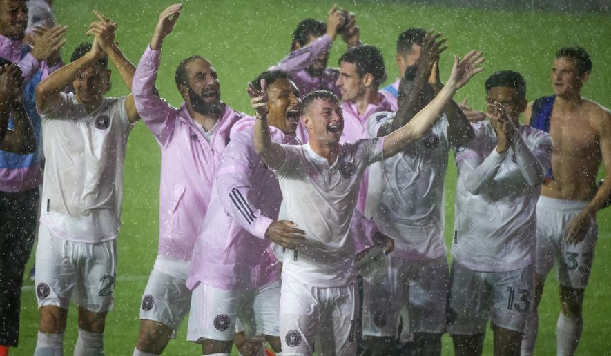 Inter Miami players greet fans in the rain after a win over FC Cincinnati in an MLS soccer match Sunday, Nov. 8, 2020, in Fort Lauderdale, Fla. (David Santiago/Miami Herald via AP)