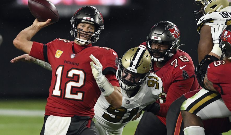 Tampa Bay Buccaneers quarterback Tom Brady (12) is pressured by New Orleans Saints defensive end Trey Hendrickson (91) as he throws a pass during the second half of an NFL football game Sunday, Nov. 8, 2020, in Tampa, Fla. (AP Photo/Jason Behnken)