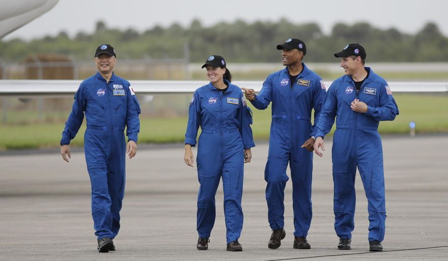 Astronaut Soichi Noguchi, of Japan, from left, NASA Astronauts Shannon Walker, Victor Glover and Michael Hopkins walk after arriving at Kennedy Space Center, Sunday, Nov. 8, 2020, in Cape Canaveral, Fla. The four astronauts will fly on the SpaceX Crew-1 mission to the International Space Station scheduled for launch on Nov. 14, 2020 (AP Photo/Terry Renna)