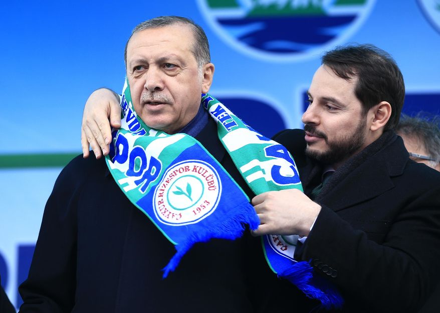 FILE - In this Monday, April 3, 2017 file photo, Berat Albayrak, right, Turkey&#39;s Energy Minister and son-in-law of Turkey&#39;s President Recep Tayyip Erdogan, left, places a soccer club scarf on his shoulders during a rally for the upcoming referendum, in his hometown city of Rize, in the Black Sea region, Turkey. Albayrak, announced his resignation on social media Sunday, Nov. 8, 2020. He said on Instagram that he was stepping down from his post for health reasons and would spend more time with his family.Albayrak, 42, was appointed minister of finance and treasury in July 2018, having previously been energy minister for nearly three years. (AP Photo/Lefteris Pitarakis, File)
