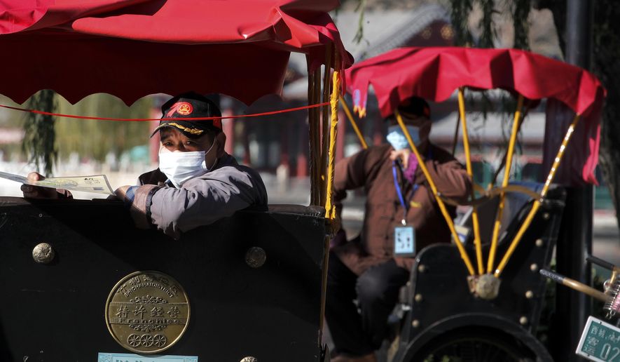 Trishaw drivers wearing face masks to help curb the spread of the coronavirus wait for customers near the Houhai Lake in Beijing, Sunday, Nov. 8, 2020. (AP Photo/Andy Wong)
