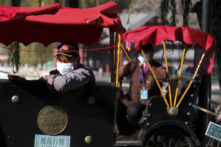 Trishaw drivers wearing face masks to help curb the spread of the coronavirus wait for customers near the Houhai Lake in Beijing, Sunday, Nov. 8, 2020. (AP Photo/Andy Wong)