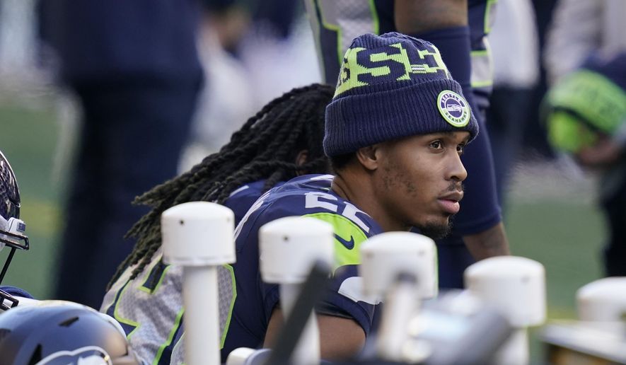 Seattle Seahawks cornerback Quinton Dunbar sits on the bench during the national anthem before an NFL football game against the San Francisco 49ers, Sunday, Nov. 1, 2020, in Seattle. (AP Photo/Elaine Thompson)
