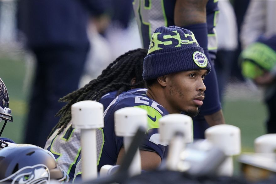 Seattle Seahawks cornerback Quinton Dunbar sits on the bench during the national anthem before an NFL football game against the San Francisco 49ers, Sunday, Nov. 1, 2020, in Seattle. (AP Photo/Elaine Thompson)