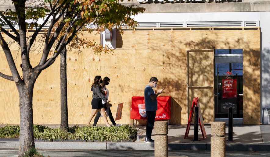 A Smoothie King on K Street in downtown Washington, is still boarded up, Monday, Nov. 9, 2020. While some storefronts downtown have begun to remove the boards protecting their windows since the election, many still remain. (AP Photo/Jacquelyn Martin)