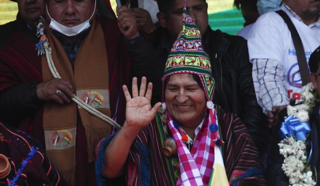 Former President Evo Morales waves during a rally with supporters in Villazon, Bolivia, Monday, Nov. 9, 2020, after he walked across a border bridge from Argentina. Morales, who fled into exile after resigning last November, returned to his homeland the day after the presidential inauguration of his former finance minister Luis Arce. (AP Photo/Juan Karita)