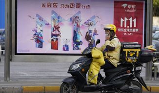 A delivery man passes by an ad for the Nov. 11 Sales Day in Beijing, China on Oct. 28, 2020. Chinese consumers are expected to spend tens of billions on everything from fresh food to luxury goods during this year&#39;s Singles&#39; Day online shopping festival, as the country recovers from the coronavirus pandemic. (AP Photo/Ng Han Guan)