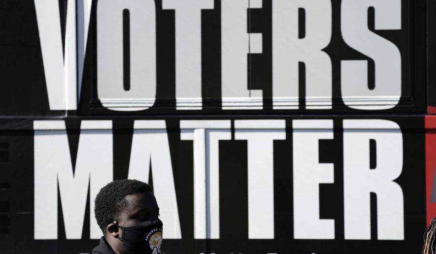 In this Nov. 3, 2020, photo, a man wearing a mask gathers with a group in support of Black Voters Matter at the Graham Civic Center polling site in Graham, N.C. Even as votes are still tallied, there&#39;s little dispute that Black voters were a driving national force pushing the former vice president to the winner’s column. (AP Photo/Gerry Broome)