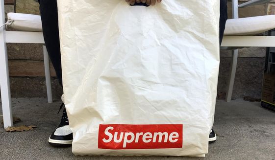 The Supreme logo appears on a plastic shopping bag in Fort Lee, N.J., Monday, Nov. 9, 2020. VF Corp., the owner of The North Face, Vans and Timberland brands, is buying privately held streetwear company Supreme as it looks to grow its online and direct-to-consumer business. (AP Photo/Pablo Salinas)