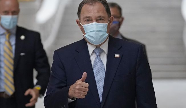 Utah Gov. Gary Herbert gives a thumbs up as he walks through the Capitol rotunda to a COVID-19 briefing Monday, Nov. 9, 2020, in Salt Lake City. Herbert declared a state of emergency Sunday night, Nov. 8 and ordered a statewide mask mandate in an attempt to stem a surge in coronavirus patient hospitalizations that is testing the state's hospital capacity. (AP Photo/Rick Bowmer)