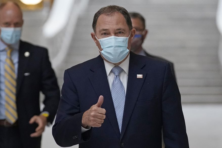 Utah Gov. Gary Herbert gives a thumbs up as he walks through the Capitol rotunda to a COVID-19 briefing Monday, Nov. 9, 2020, in Salt Lake City. Herbert declared a state of emergency Sunday night, Nov. 8 and ordered a statewide mask mandate in an attempt to stem a surge in coronavirus patient hospitalizations that is testing the state's hospital capacity. (AP Photo/Rick Bowmer)