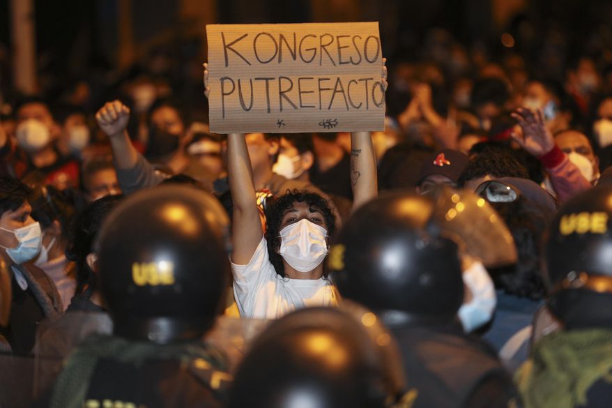 A man holds a sign reading in Spanish &amp;quot;Rotten Congress&amp;quot; during a protest against Congress decision to oust President Martin Vizcarra in Lima, Peru, Monday, Nov. 9, 2020. Peruvian lawmakers voted overwhelmingly Monday night to remove Vizcarra from office, expressing anger over his handling of the coronavirus pandemic and citing alleged but unproven corruption allegations. (AP Photo/Martin Mejia)