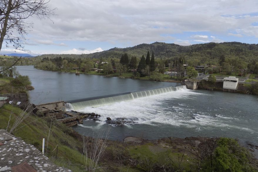 This photo provided by Jim McCarthy shows the Winchester Dam in Winchester, Ore., on April 19, 2019. Environmental and fishing groups are suing a small, private water district in southern Oregon over the 130-year-old dam on a pristine stretch of the North Umpqua River. The lawsuit, filed in U.S. District Court in Eugene, asks a judge to order the Winchester Water Control District to build a new fish ladder on the Winchester Dam and make major repairs to the overall dam, which is on a national historic registry. (JimMcCarthy/WaterWatch via AP)
