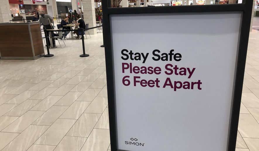 A sign spells out the rules of social distancing in a Lakewood, Colorado, mall. Some critics, however, are uneasy with how far the restrictions can go. (AP Photo/David Zalubowski)