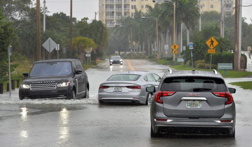 A driver navigates around vehicles stalled in Sarasota, Florida, on Wednesday as Eta passes to the west.