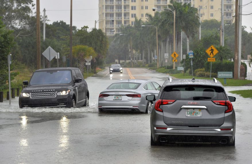 A driver navigates around vehicles stalled in Sarasota, Florida, on Wednesday as Eta passes to the west.