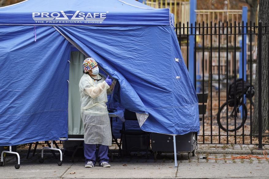Medical works operate a testing tent at a COVID-19 mobile testing site, Wednesday, Nov. 11, 2020, in the Brooklyn borough of New York. Restaurants, bars and gyms will have to close at 10 p.m. across New York state in the latest effort to curb the spread of the coronavirus, Gov. Andrew Cuomo announced Wednesday. Cuomo said the new restrictions, which go into effect Friday, are necessary because new coronavirus infections have been traced to those types of activities. (AP Photo/John Minchillo)