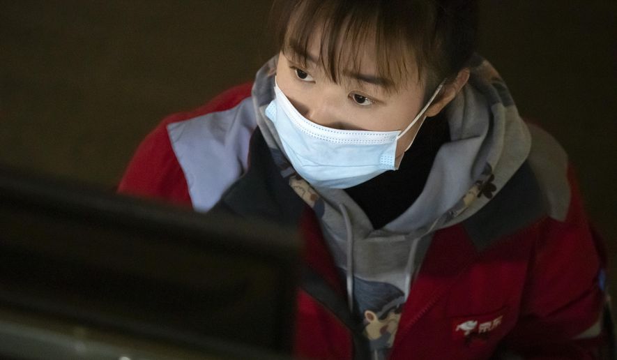 An employee looks at a computer terminal as she monitors an automated parcel handling line at a warehouse for online retailer JD.com in Beijing, Wednesday, Nov. 11, 2020. Chinese consumers spent over a hundred billion dollars during this year’s Singles’ Day shopping festival, signaling a rebound in consumption as China recovers from the coronavirus pandemic and a battering of the economy. (AP Photo/Mark Schiefelbein)