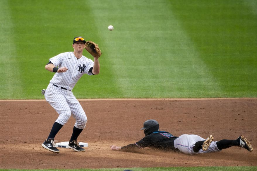 File-This Sept. 26, 2020, file photo shows Miami Marlins&#39; Jon Berti stealing second base as New York Yankees second baseman DJ LeMahieu waits for the throw during the third inning of a baseball game at Yankee Stadium in New York.  Houston Astros outfielder George Springer,  LeMahieu, and Philadelphia catcher J.T. Realmuto were among just six free agents who received $18.9 million qualifying offers on Sunday, Nov. 1, 2020, from their former teams. Three right-handed pitchers also received the offers, Cincinnati’s Trevor Bauer, the New York Mets’ Marcus Stroman, and San Francisco&#39;s Kevin Gausman. (AP Photo/Corey Sipkin, File)