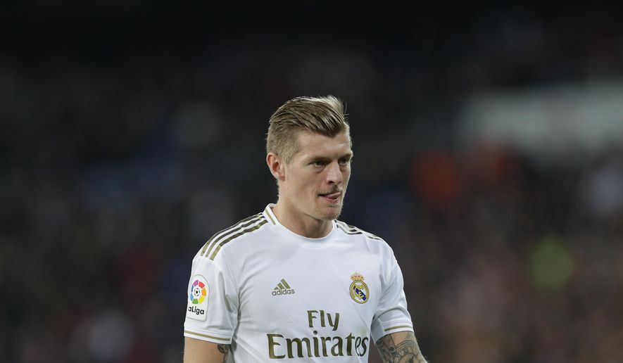 FILE - In this Sunday, Feb. 16, 2020 file photo, Real Madrid&#39;s Toni Kroos looks on during their Spanish La Liga soccer match against Celta de Vigo at the Santiago Bernabeu stadium in Madrid, Spain. Kroos has criticized soccer authorities UEFA and FIFA for a crowded schedule, suggesting they overlook players’ interests in favor of their own. “At the end of the day, we players are just the puppets of FIFA and UEFA with all these additional (competitions) that are invented. Nobody is asked,” Kroos said Wednesday, Nov. 11 in a podcast called “Einfach mal Luppen” that he regularly hosts with his brother Felix Kroos, who plays for German second-division team Eintracht Braunschweig. (AP Photo/Manu Fernandez, file)
