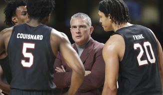 FILE - In this March 7, 2020, file photo, South Carolina head coach Frank Martin talks to Jermaine Couisnard (5) and Alanzo Frink (20) in the second half of an NCAA college basketball game against Vanderbilt in Nashville, Tenn. South Carolina coach Frank Martin carries a new perspective into this season with the Gamecocks. Martin caught COVID-19 during the spring when fear of the disease was spiking and few people knew how to deal with it. But Martin&#39;s time in isolation and recovery led to a deeper appreciation of when he and his players would return to the court. (AP Photo/Mark Humphrey, File)