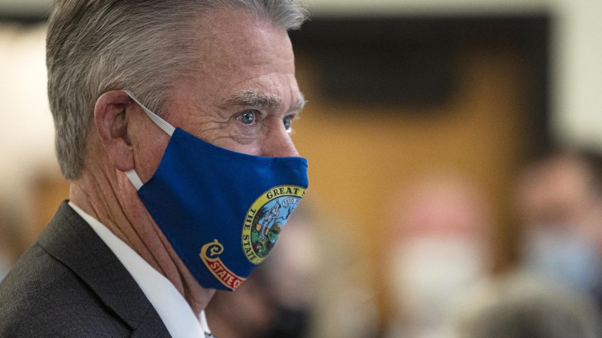 FILE - In this Sept. 18, 2020, file photo, Idaho Gov. Brad Little wears a protective mask printed with his state's flag in Boise, Idaho, before announcing a COVID reopening plan. Earlier this week, Little again urged Idahoans to wear masks, wash hands and practice social distancing to slow the spread of the coronavirus. But he has declined to issue a statewide mask mandate, instead leaving the decision up to regional health districts. (Darin Oswald/Idaho Statesman via AP, File)