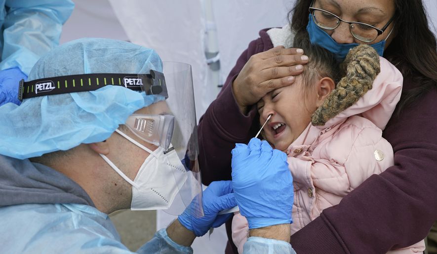 FILE - In this Nov. 10, 2020, file photo, Kim Tapia holds her granddaughter Amariah Lucero, 3, as she's tested at the Utah National Guard's mobile testing site for COVID-19 in Salt Lake City. The U.S. has recorded about 10.3 million confirmed infections, with new cases soaring to all-time highs of well over 120,000 per day over the past week. (AP Photo/Rick Bowmer, File)