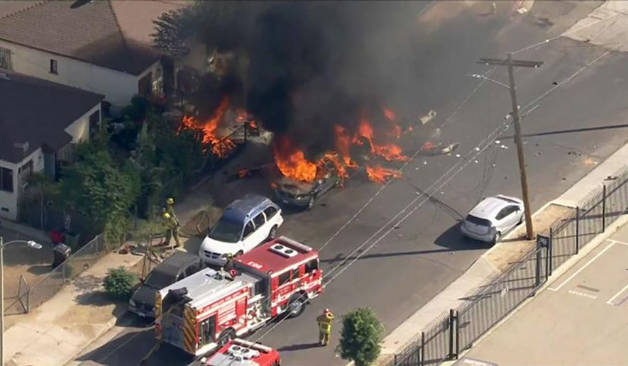 In this photo taken from video provided by KTLA-TV, is a small plane that crashed and burned on a street just outside a small airfield in Los Angeles' San Fernando Valley, Thursday, Nov. 12, 2020. A KTLA news helicopter overhead showed fire burning parked cars in the street and on a lawn of a house in a neighborhood off one end of Whiteman Airport's single runway in the Pacoima area about 15 miles northwest of downtown Los Angeles. (KTLA-TV via AP)