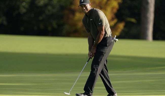 Tiger Woods watches his ball as he misses a birdie putt on the eighth hole during the first round of the Masters golf tournament Thursday, Nov. 12, 2020, in Augusta, Ga. (AP Photo/Charlie Riedel)
