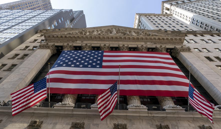 FILE - In this Monday, Sept. 21, 2020, file photo, a giant American Flag hangs on the New York Stock Exchange.  Wall Street is moving past the uncertainty of election season and, if history is a guide, investors can indeed breathe a sigh of relief. Stocks typically post solid gains following an election, no matter which party controls the White House or Congress.  (AP Photo/Mary Altaffer, File)