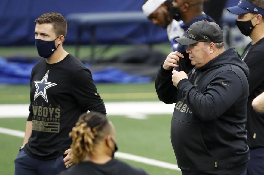 Dallas Cowboys head coach Mike McCarthy, right, adjust his mask as he and offensive coordinator Kellen Moore, left, watch warmups before an NFL football game against the Pittsburgh Steelers in Arlington, Texas, Sunday, Nov. 8, 2020. (AP Photo/Roger Steinman)