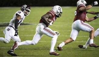 South Carolina wide receiver Shi Smith, center, carries the ball next to Texas A&amp;amp;M defensive back Keldrick Carper (14) during the second half of an NCAA college football game Saturday, Nov. 7, 2020, in Columbia, S.C. Texas A&amp;amp;M won 48-3. (AP Photo/Sean Rayford)