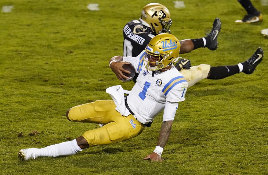 UCLA quarterback Dorian Thompson-Robinson, front, slides to a stop past Colorado cornerback Chris Miller after a long gain in the second half of an NCAA college football game Saturday, Nov. 7, 2020, in Boulder, Colo. (AP Photo/David Zalubowski)
