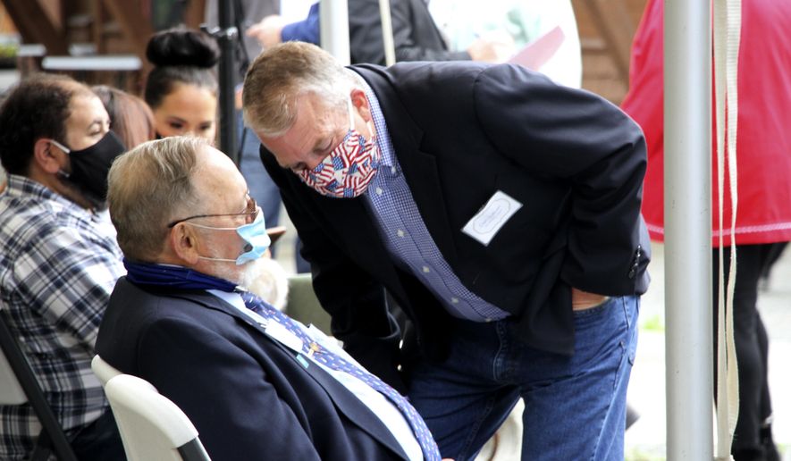 In this Aug. 26, 2020, photo, a masked U.S. Sen. Dan Sullivan leans down to speak to U.S. Rep. Don Young, also masked, before a ceremony in Anchorage, Alaska, celebrating the opening of a Lady Justice Task Force cold case office which will specialize in cases involving missing or murdered Indigenous women. Young announced Thursday, Nov. 12, 2020, on Twitter that he has tested positive for COVID-19. (AP Photo/Mark Thiessen)