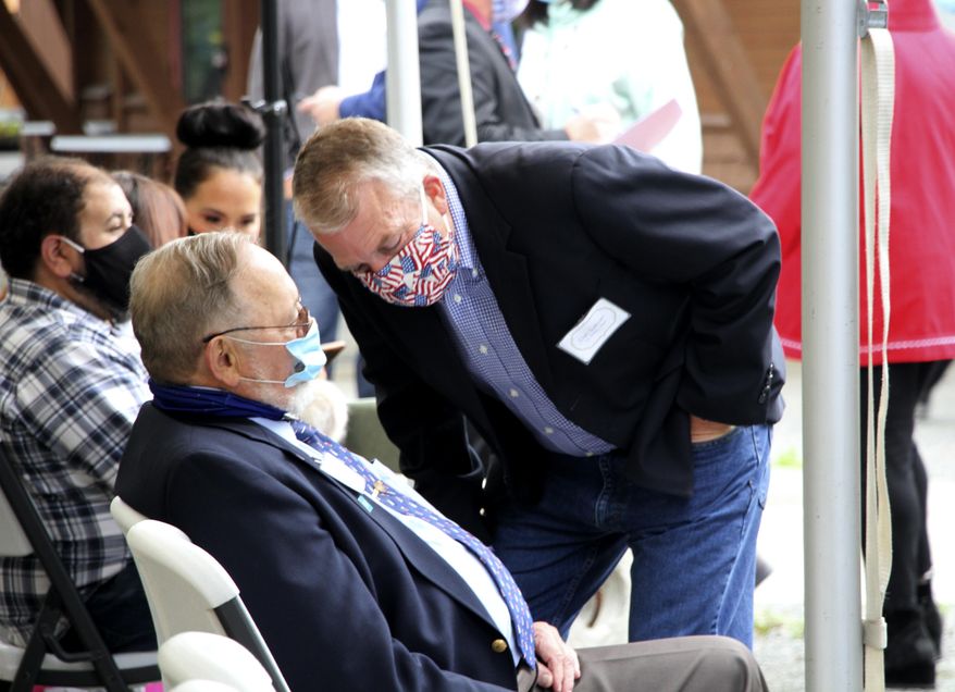 In this Aug. 26, 2020, photo, a masked U.S. Sen. Dan Sullivan leans down to speak to U.S. Rep. Don Young, also masked, before a ceremony in Anchorage, Alaska, celebrating the opening of a Lady Justice Task Force cold case office which will specialize in cases involving missing or murdered Indigenous women. Young announced Thursday, Nov. 12, 2020, on Twitter that he has tested positive for COVID-19. (AP Photo/Mark Thiessen)