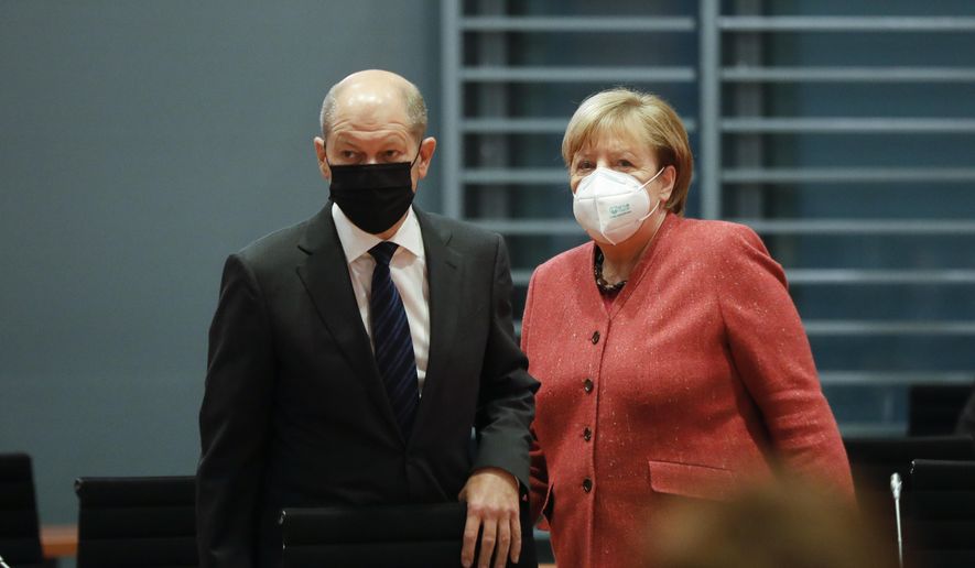 German Chancellor Angela Merkel, right, and German Finance Minister Olaf Scholz arrive at the weekly cabinet meeting of the German government at the chancellery in Berlin, Germany, Wednesday, Nov. 11, 2020. (AP Photo/Markus Schreiber, pool)