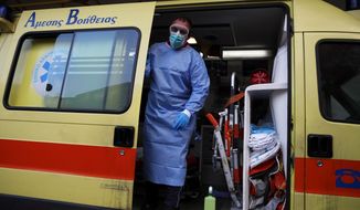 A paramedic wearing a suit to protect against coronavirus, closes the door of an ambulance at Evangelismos hospital in Athens, Thursday, Nov. 12, 2020. Greece has imposed a nationwide nightly curfew as the number of COVID-19 cases in the country continues to surge despite a lockdown. (AP Photo/Thanassis Stavrakis)