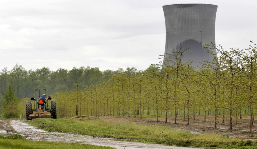 FILE - In this May 18, 2011, file photo, a worker is seen in the area surrounding a tree farm in North Perry, Ohio, near the two cooling towers of the Perry Nuclear Power Plant looming in the background. Amid intense scrutiny of the roles company officials played in an alleged $60 million bribery scheme to obtain a $1 billion bailout for two aging nuclear power plants, Ohio&#39;s largest electric utility has announced a goal to become &amp;quot;carbon neutral&amp;quot; by 2050 while reducing greenhouse gas emissions 30% by 2030. (AP Photo/Amy Sancetta, File)