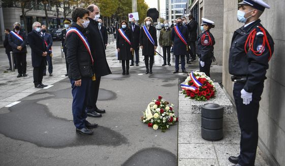 Saint-Denis Mayor Mathieu Hanotin, left, and French Prime Minister Jean Castex participate in a wreath-laying ceremony, marking the 5th anniversary of the Nov. 13, 2015, attacks outside the stadium Stade de France in Saint Denis, near Paris, Friday, Nov. 13, 2020. In silence and mourning, France is marking five years since 130 people were killed by Islamic State extremists who targeted the Bataclan concert hall, Paris cafes and the national stadium. (Christophe Archambault/Pool Photo via AP)