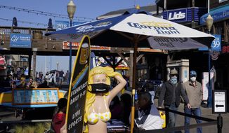 A mannequin wears a face mask in front of outdoor seating at the Wipeout Bar and Grill at Pier 39 during the coronavirus outbreak in San Francisco, Thursday, Nov. 12, 2020. (AP Photo/Jeff Chiu)