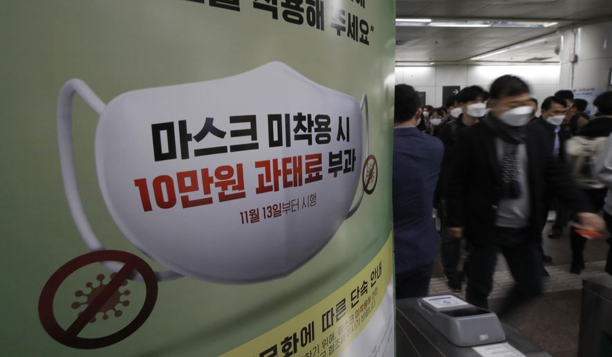 People wearing face masks as a precaution against the coronavirus, walk past near a banner reading: &amp;quot;People who do not wear masks in public will face a 100,000 won ($90) fine&amp;quot;, at a subway station in Seoul, South Korea, Friday, Nov. 13, 2020. South Korea has reported its biggest daily jump in COVID-19 cases in 70 days as the government began fining people who fail to wear masks in public. From Friday, officials started to impose fines of up to 100,000 won ($90) for people who fail to properly wear masks in public transport and a wide range of venues, including hospitals, nursing homes, pharmacies, nightclubs, karaoke bars, religious and sports facilities and at gatherings of more than 500 people. (AP Photo/Lee Jin-man)