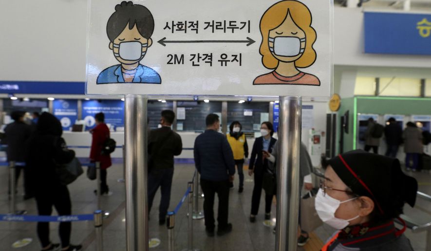 A social distancing sign is seen as people wait to buy tickets at the Seoul Railway Station in Seoul, South Korea, Friday, Nov. 13, 2020. South Korea has reported its biggest daily jump in COVID-19 cases in 70 days as the government began fining people who fail to wear masks in public. The Korean letters read &amp;quot;Social distance and keep 2 meter away.&amp;quot;(AP Photo/Ahn Young-joon)