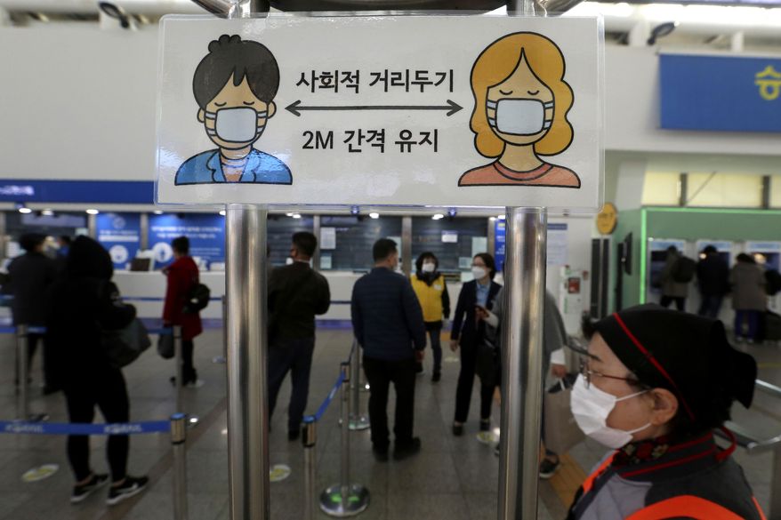 A social distancing sign is seen as people wait to buy tickets at the Seoul Railway Station in Seoul, South Korea, Friday, Nov. 13, 2020. South Korea has reported its biggest daily jump in COVID-19 cases in 70 days as the government began fining people who fail to wear masks in public. The Korean letters read &amp;quot;Social distance and keep 2 meter away.&amp;quot;(AP Photo/Ahn Young-joon)